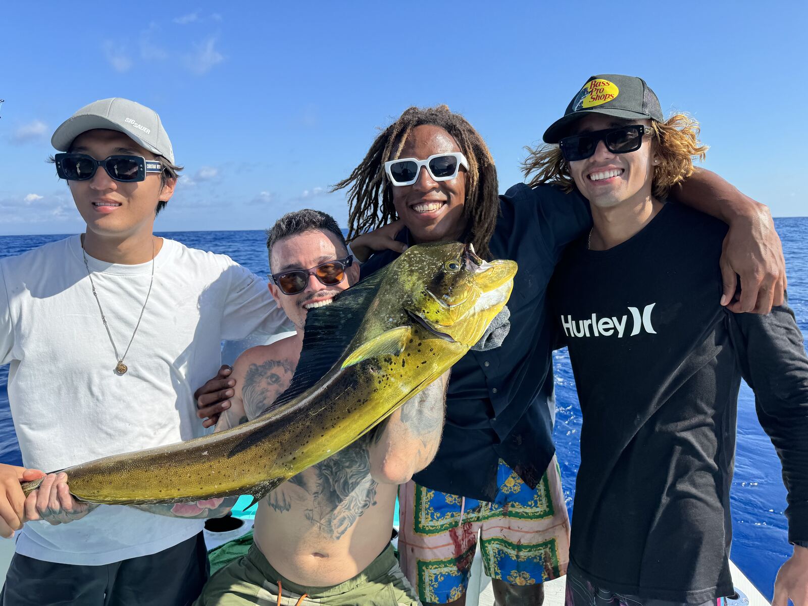 A group of friends celebrating a mahi-mahi catch