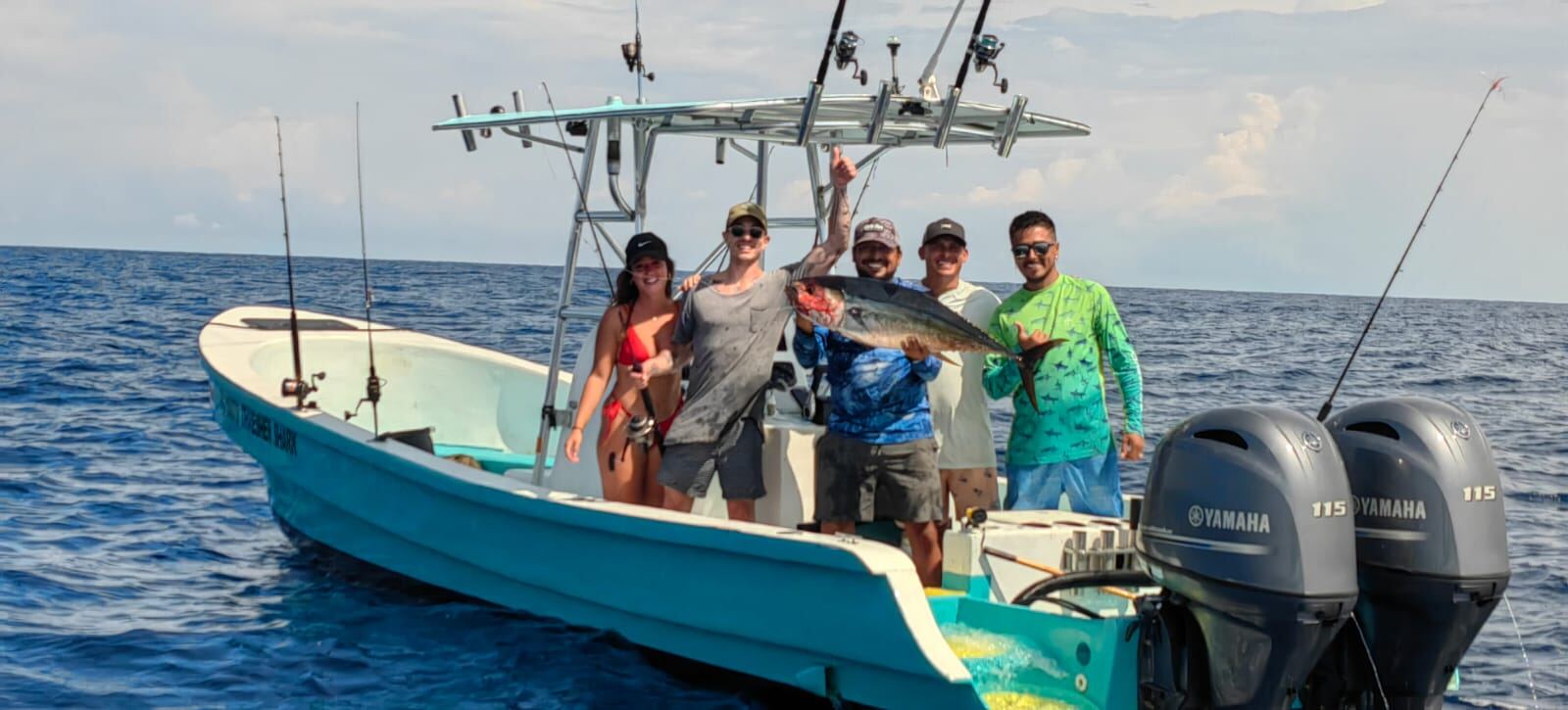 Group celebrating a tuna catch offshore